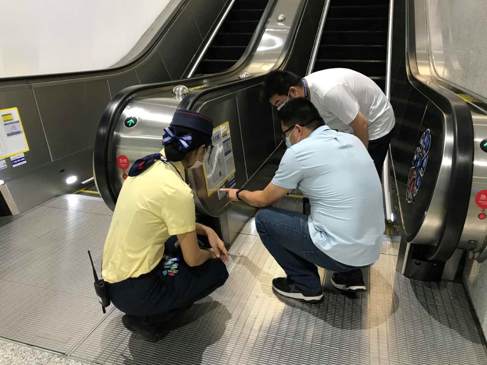 图片三为执法人员对超市手扶电梯进行安全检查.jpg