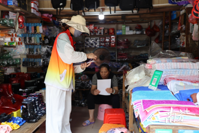 企业志愿突击队到沿街商铺发放防蚊灭蚊宣传资料。邱淑平 摄